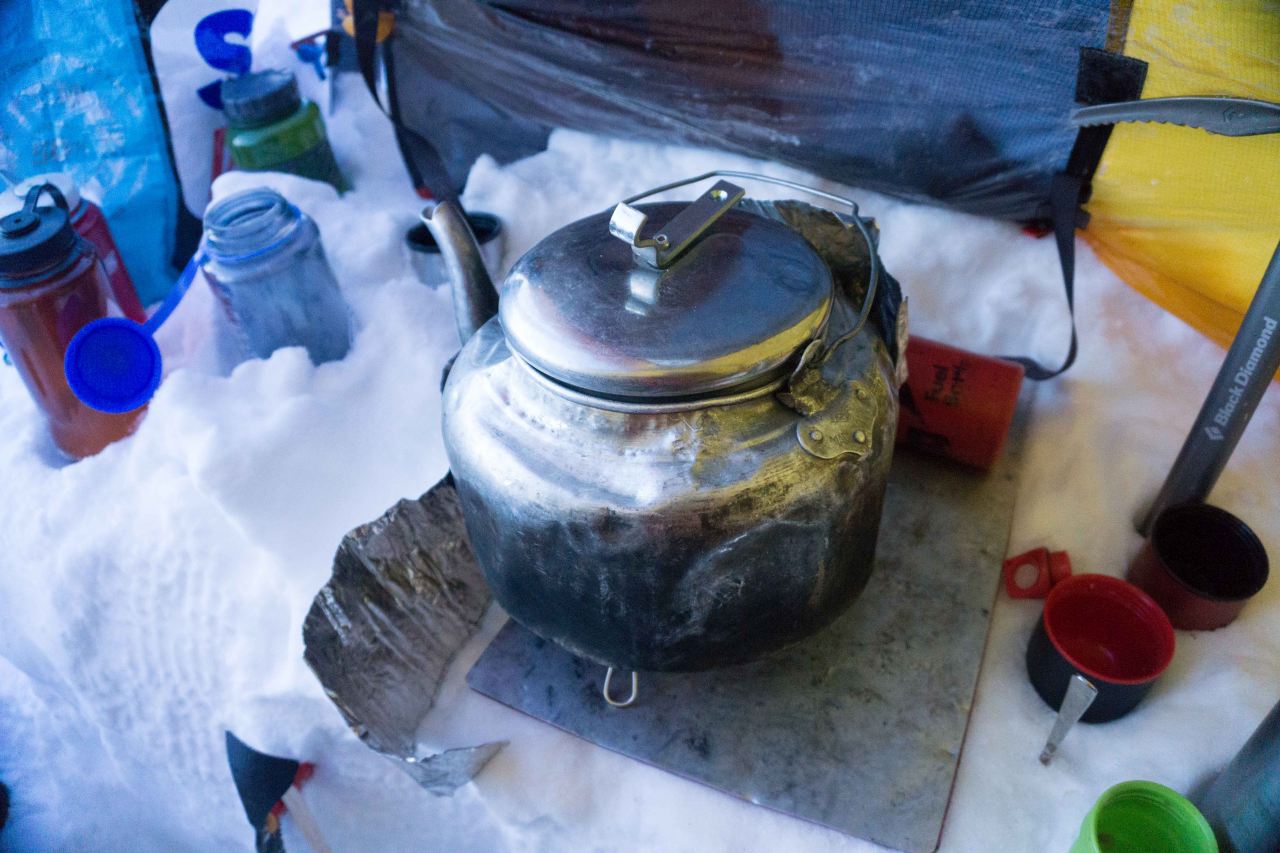 Water being boiled in a kettle in the snow in a tent on a glacier on a polar training course with Icelandic Mountain Guides
