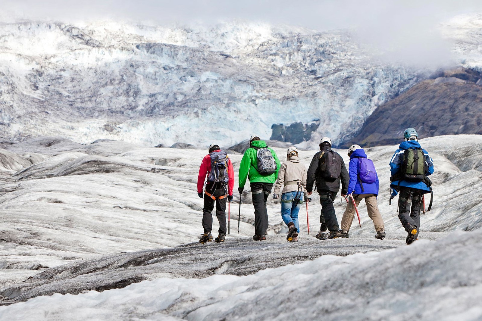 Group of hikers on the glacier going deeper into the valley towards the icefall