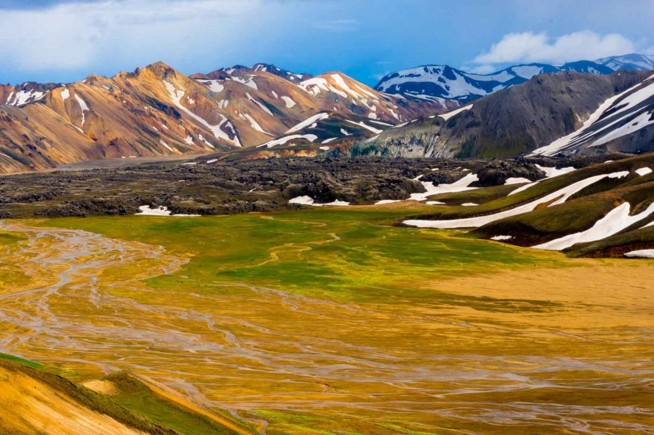 The colorful rhyolite mountains in Landamannalaugar and green field and river.